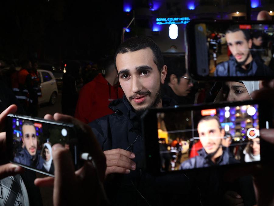 Un prigioniero appena rilasciato gesticola tra sostenitori che tengono in mano i telefoni durante una cerimonia di benvenuto in seguito al rilascio di prigionieri palestinesi dalle carceri israeliane in cambio di ostaggi israeliani tenuti a Gaza da Hamas . (Photo by Jaafar ASHTIYEH / AFP)