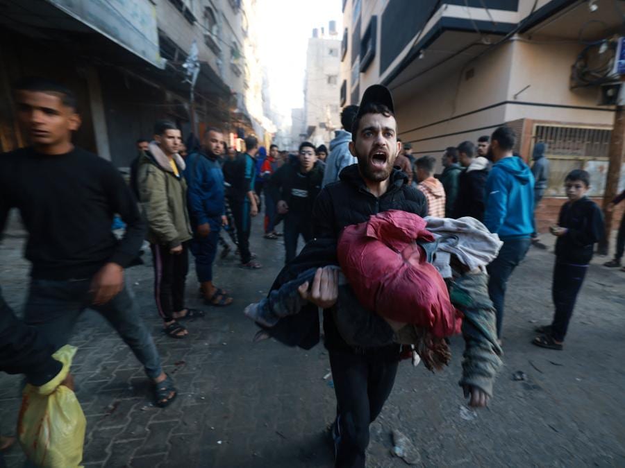 La gente corre al riparo in seguito alla ripresa dei bombardamenti israeliani a Rafah, nel sud della Striscia di Gaza. (Photo by MOHAMMED ABED / AFP)