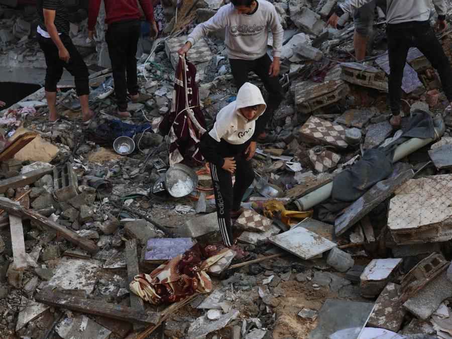 Palestinesi ispezionano la distruzione seguita a un attacco israeliano a Rafah, nel sud della Striscia di Gaza. (Photo by SAID KHATIB / AFP)