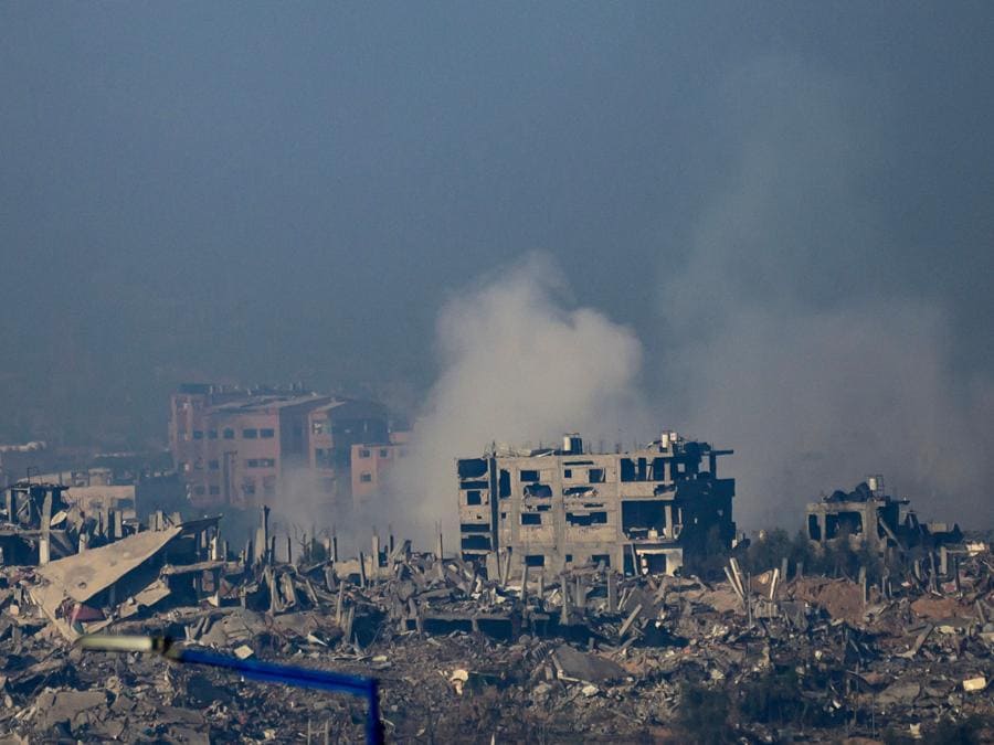 Questa foto scattata dal sud di Israele vicino al confine con la Striscia di Gaza mostra il fumo che sale dagli edifici ancora fumanti dopo essere stati colpiti dagli attacchi israeliani negli scontri tra Israele e militanti di Hamas. (Photo by John MACDOUGALL / AFP)
