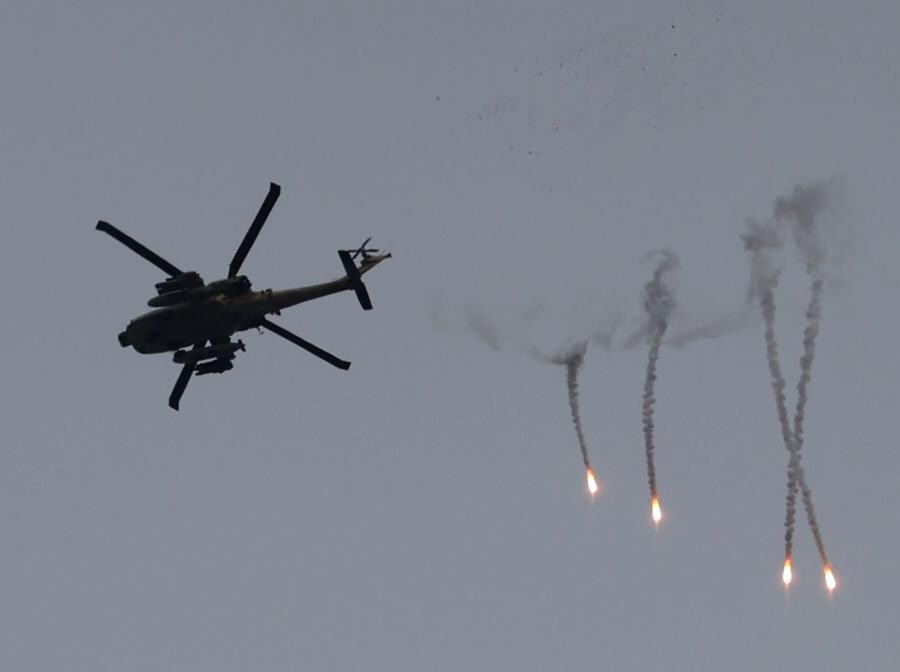 Un elicottero Apache israeliano spara razzi vicino al confine della Striscia di Gaza, nel sud di Israele. EPA/ABIR SULTAN
