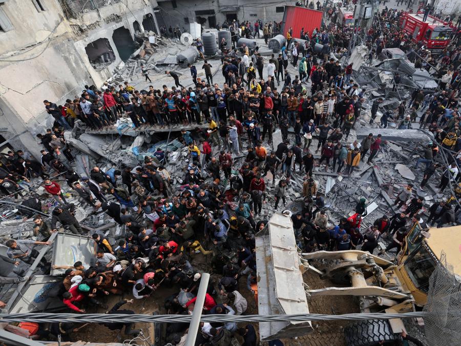 Palestinesi cercano vittime sul luogo di un attacco israeliano contro una casa, nel mezzo del conflitto in corso tra Israele e il gruppo islamico palestinese Hamas, a Rafah, nel sud della Striscia di Gaza. REUTERS/Ibraheem Abu Mustafa
