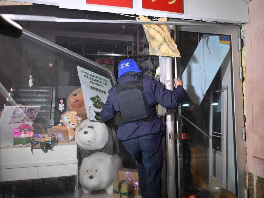 Un soccorritore ispeziona un negozio distrutto da un attacco russo a Kharkiv, alla ricerca di possibili vittime. (AFP)
