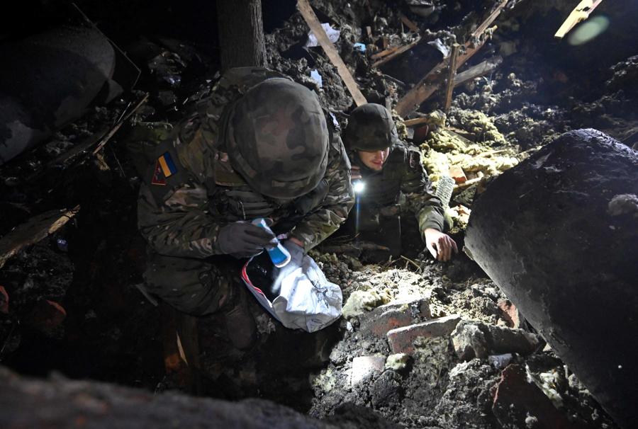 Militari ispezionano un edificio distrutto da un bombardamento russo a Kharkiv. (AFP)