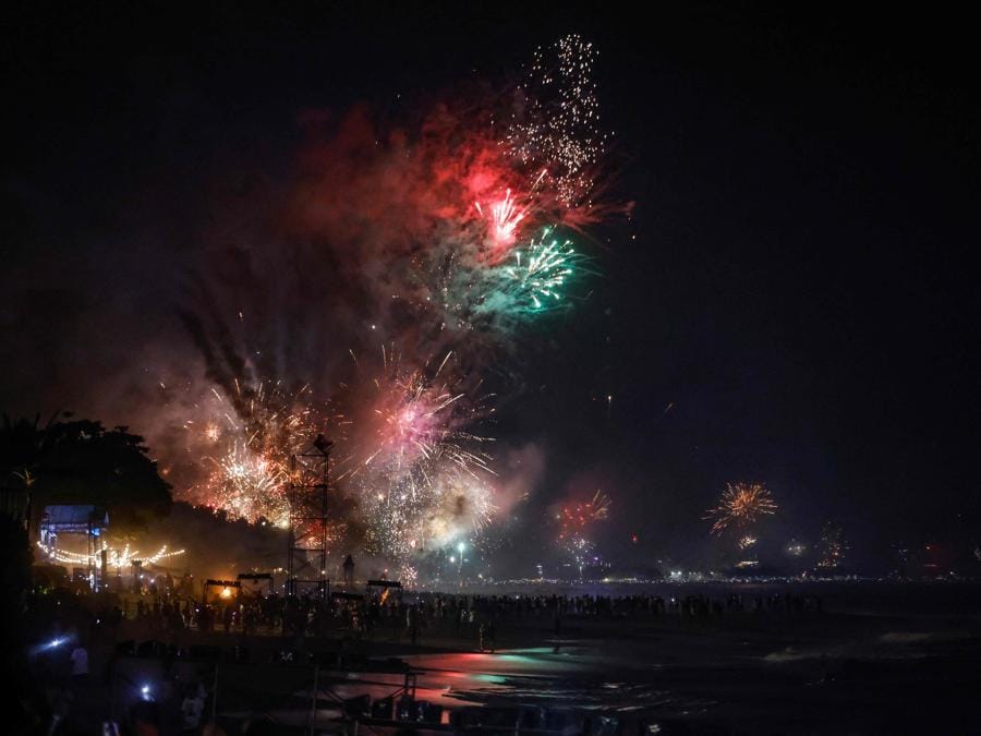 Festeggiamenti su una spiaggia nel distretto di Kerobokan sull’isola turistica di Bali, Indonesia. (Photo by David Gannon / AFP)