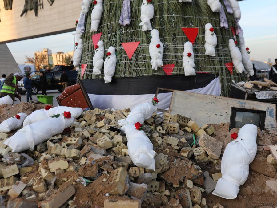 Iracheni camminano vicino a un albero di Natale decorato con bare simboliche che rappresentano le vittime di Gaza in piazza Tahrir nel centro di Baghdad, Iraq. EPA/AHMED JALIL
