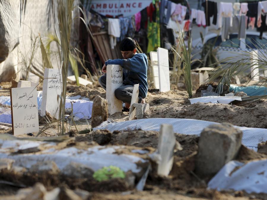 I palestinesi visitano le tombe delle persone uccise nel bombardamento israeliano della Striscia di Gaza e sepolte all’interno dell’ospedale Shifa a Gaza City. (AP Photo/Mohammed Hajjar)