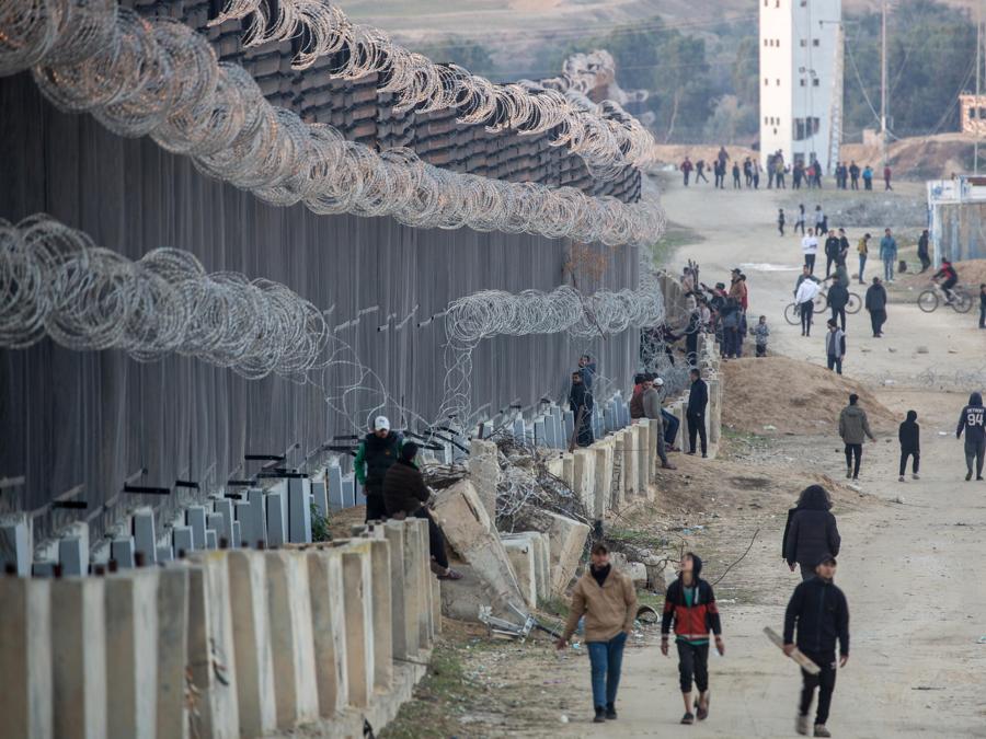 Palestinesi sfollati camminano vicino al confine palestinese-egiziano nel campo di Rafah, nel sud della Striscia di Gaza. EPA/HAITHAM IMAD