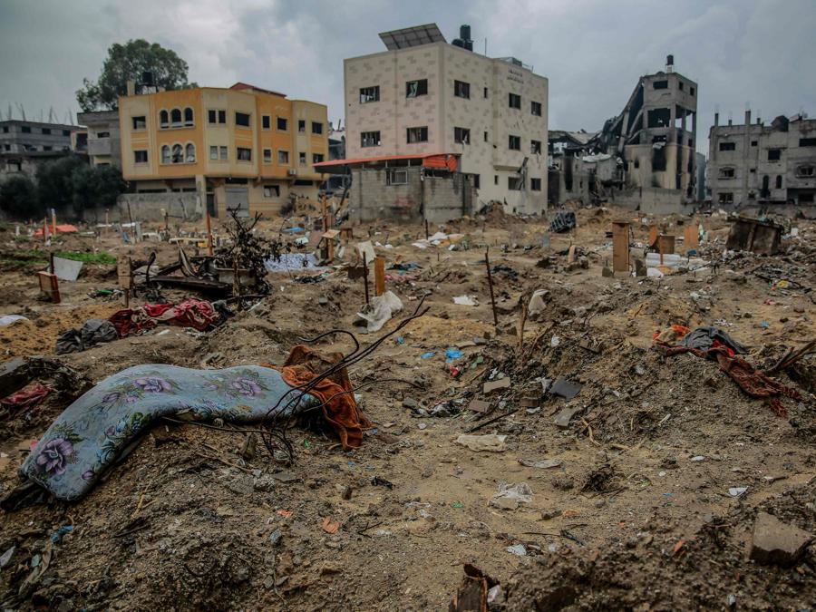 Un cimitero improvvisato nel quartiere orientale di al-Tuffah a Gaza City dopo che, secondo quanto riferito, è stato raso al suolo dalle forze israeliane. (Photo by AFP)