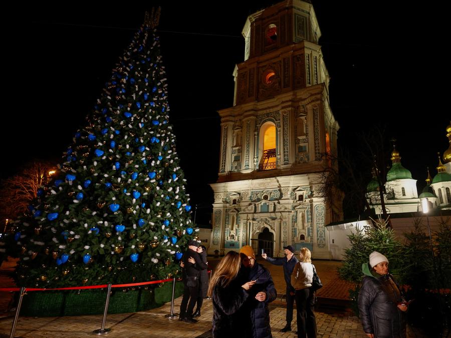 Le persone si riuniscono accanto a un albero di Natale per festeggiare il Capodanno,  di fronte alla Cattedrale di Santa Sofia a Kiev, Ucraina. REUTERS/Valentyn Ogirenko