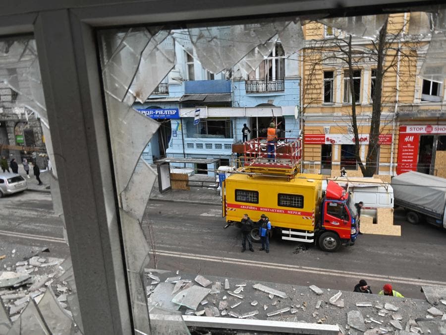 I lavoratori dei servizi pubblici ripuliscono i detriti e le finestre rotte a seguito di un attacco di droni russi a Kharkiv. (Photo by SERGEY BOBOK / AFP)
