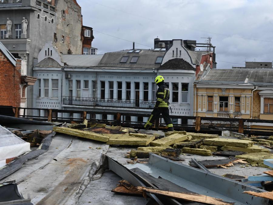 Un vigile del fuoco lavora sul tetto di un edificio gravemente danneggiato a seguito di un attacco di droni russi a Kharkiv. (Photo by SERGEY BOBOK / AFP)