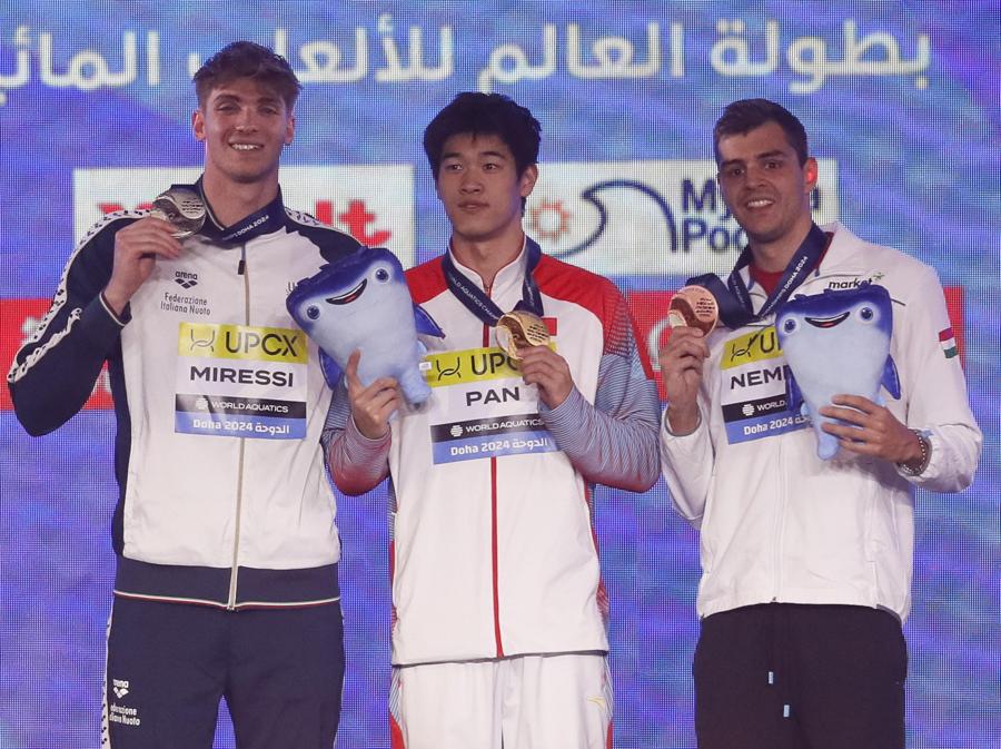 15 febbraio 2024 - Sul podio da sinistra: l’italiano Alessandro Miressi  medaglia d’argento, il cinese Zhanle Pan medaglia d’oro e ungherese Nandor Nemeth medaglia di bronzo posano dopo la cerimonia di premiazione per la finale maschile di 100 metri stile libero ai Campionati mondiali d’acqua FINA di Doha. (EPA/Yuri Kochetkov)