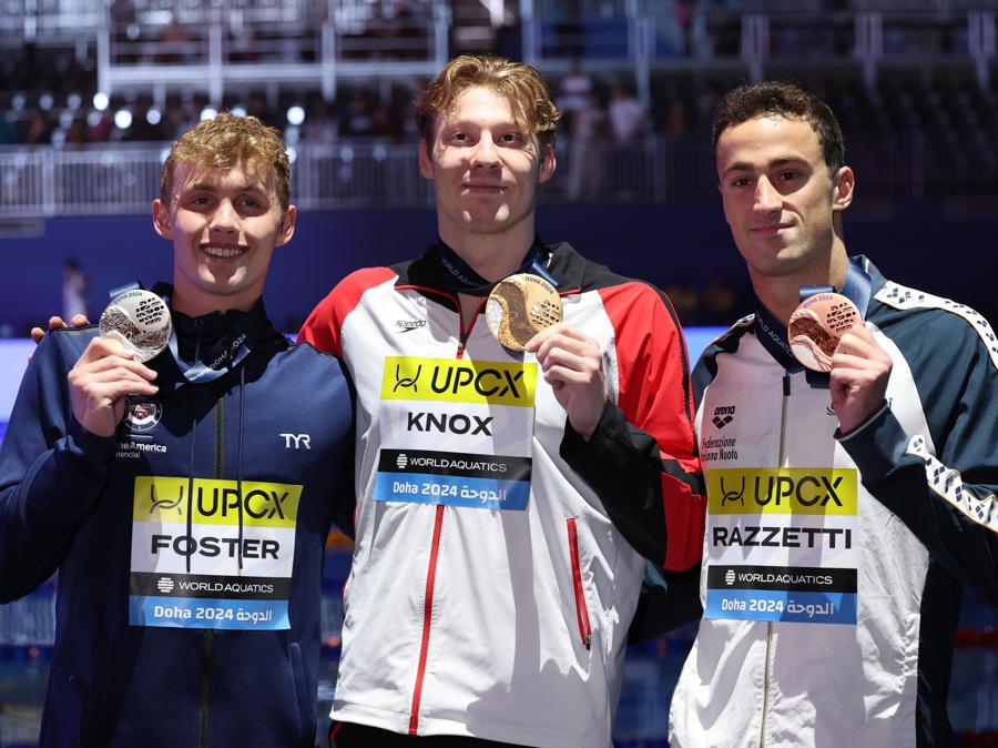 15 febbraio 2024 - Sul podio da sinistra: lo statunitense medaglia d’argento Carson Foster, il canadese Finlay Knox medaglia d’oro e l’italiano Alberto Razzetti  medaglia di bronzo posano per la finale maschile dei 200 metri misti individuali ai Campionati mondiali di nuoto FINA Doha. (EPA/Ali Haider)