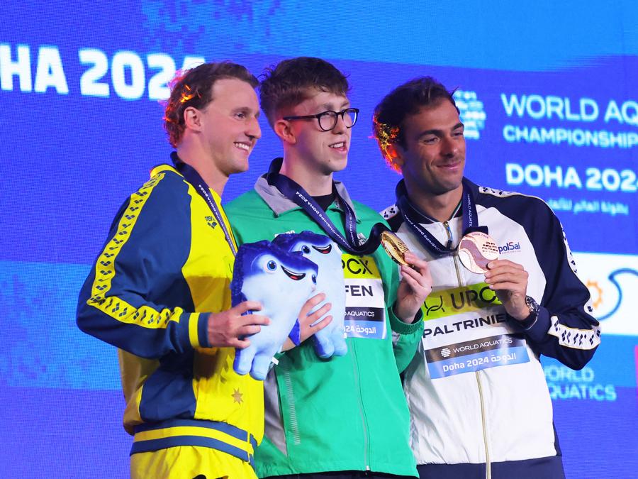 14 febbraio 2024  - Sul podio  l’irlandese Daniel Wiffen,  medaglia d’oro, festeggia la vittoria della finale maschile degli 800 metri stile libero insieme all’australiano Elijah Winnington  medaglia d’argento e all’italiano Gregorio Paltrinieri medaglia di bronzo. (REUTERS/Evgenia Novozhenina)