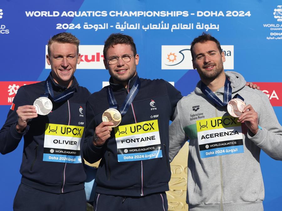 7 febbraio 2024 - Sul podio da sinistra a destra il francese Marc-Antoine Olivier medaglia d’argento, il francese Logan Fontaine medaglia d’oro  e l’italiano Domenico Acerenza medaglia di bronzo  posano durante la cerimonia di premiazione della finale maschile di 5 km in acque libere ai Campionati Mondiali di nuoto FINA di Doha 2024 in  Qatar. (EPA/Ali Haider)