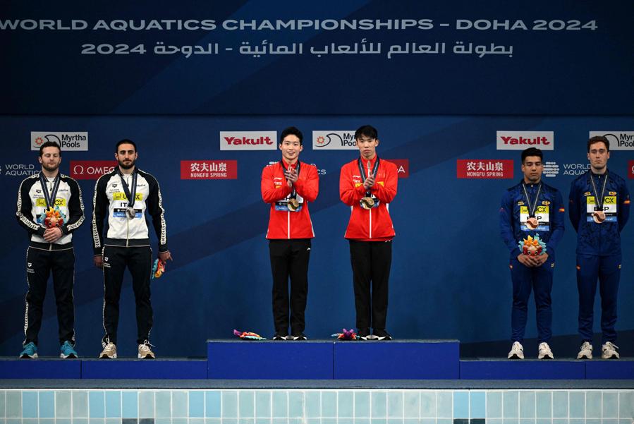 4 febbraio 2024 - Sul podio: al centro l’oro ai cinesi Wang Zongyuan e Long Daoyi, a sinistra la medaglia d’argento agli italiani Giovanni Tocci e Lorenzo Marsaglia e a destra il bronzo agli spagnoli Adrian Abadia e Nicolas Garcia Boissier posano durante la cerimonia di premiazione della finale del trampolino di 3 metri sincronizzato maschile, durante i Campionati mondiali di nuoto 2024 all’Hamad Aquatics Center di Doha. (Photo by Oli Scarff / AFP)