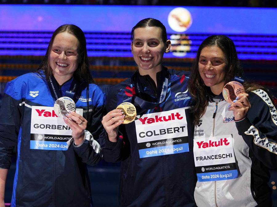 18 febbraio 2024 - Sul podio da sinistra:   l’israeliana Anastasia Gorbenko medaglia d’argento, la medaglia d’oro dell’inglese Freya Constance Colbert e la medaglia di bronzo dell’italiana Sara Franceschi, posano per la finale individuale mista dei 400 metri femminili ai Campionati mondiali di nuoto di Doha. (AP Photo/Hassan Ammar)
