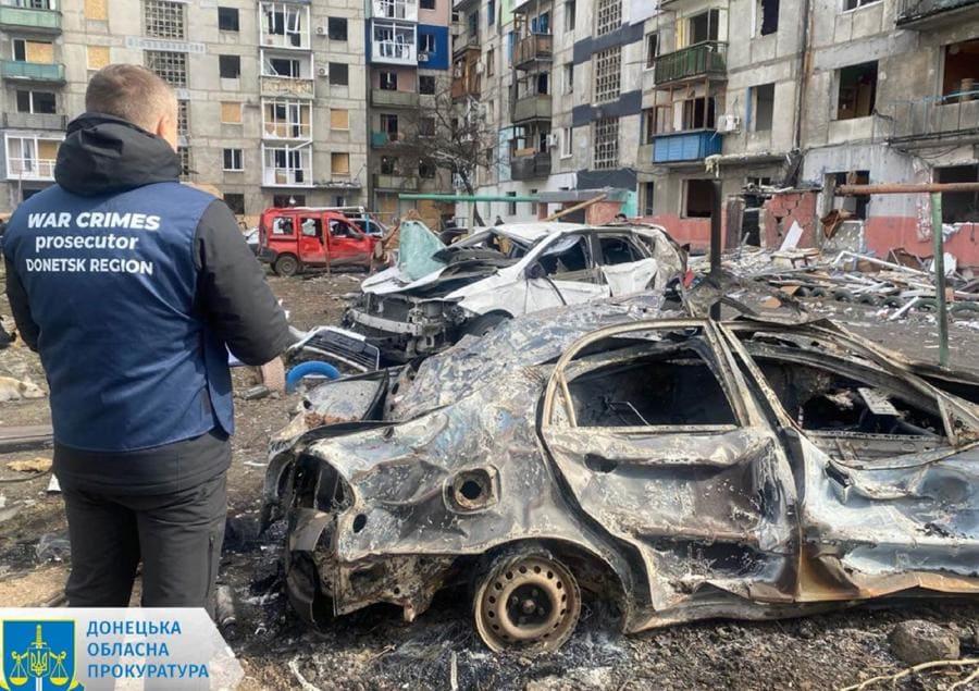 This handout photograph taken and released by Donetsk Region Prosecutor`s Office on March 10, 2024 shows a war crimes prosecutor standing next to destroyed cars in the courtyard of a damaged residential building following a missile attack in Myrnohrad, Donetsk region. A Russian night-time strike on the east Ukrainian town of Myrnograd wounded at least 11 people, Kyiv said on March 10, 2024, while Moscow launched attack drones across the country. (AFP)