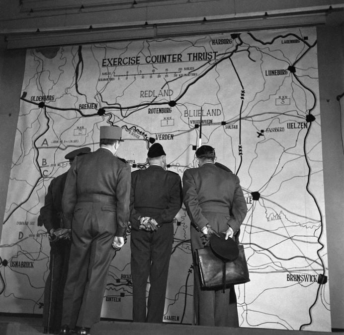 Gli ufficiali alleati guardano una mappa al posto di comando durante l’esercitazione congiunta “Counter Thrust” dell’Organizzazione del Trattato del Nord Atlantico (NATO) tenutasi nel settembre 1951 nel settore britannico della Germania con gli eserciti di sette nazioni del Patto Atlantico. Nel settembre 1951, dal 15 al 23 settembre, nella zona britannica della Germania ebbe luogo un’esercitazione tattica su larga scala chiamata Counter Thrust con forze terrestri e aeree statunitensi, britanniche (Esercito britannico del Reno (BAOR) e 2a forza aerea tattica). , eserciti belgi, olandesi, norvegesi, danesi e francesi. (Photo by AFP)
