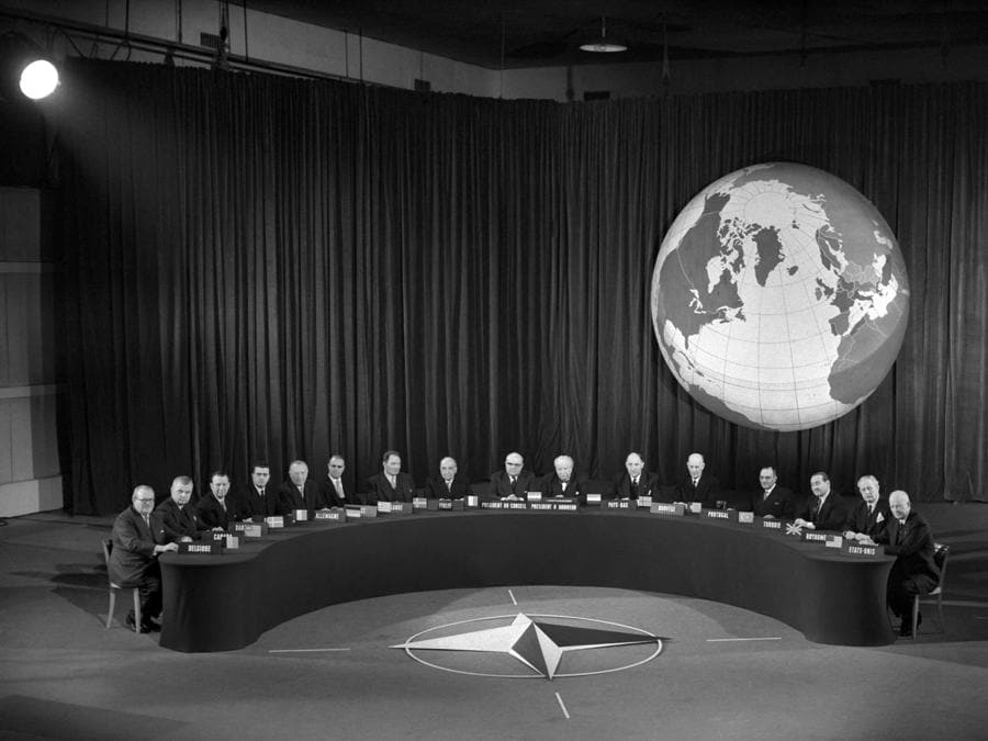 Il segretario generale della NATO Paul-Henri Spaak (al centro) legge alla stampa la dichiarazione finale della Conferenza dei capi degli Stati al Palais de Chaillot a Parigi il 19 dicembre 1957. Il presidente degli Stati Uniti Dwight “Ike” Eisenhower seduto a destra , accanto al premier britannico Harold Macmillan, e il cancelliere tedesco Konrad Adenauer è il quinto da sinistra. (Photo by INTERCONTINENTALE / AFP)
