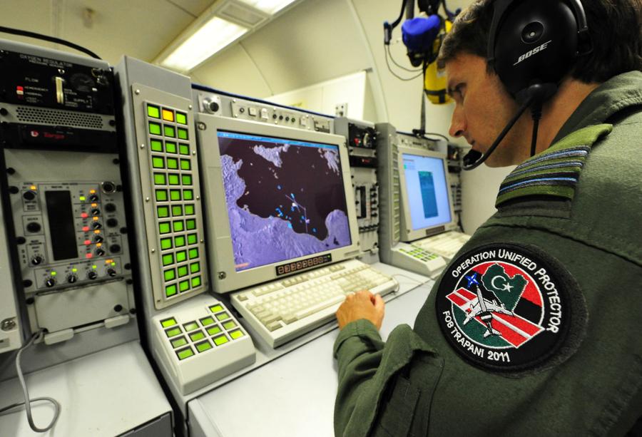 Un membro dell’equipaggio al lavoro all’interno di un un team di analisti e consulenti legali in un centro per le operazioni aeree della NATO in Italia, 9 luglio 2011. (Photo by Alberto Pizzoli / AFP)