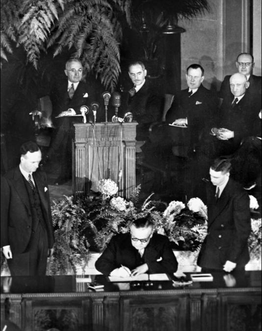 Il ministro degli Esteri britannico Ernest Bevin firma il 4 aprile 1949 il trattato del Nord Atlantico durante una cerimonia ufficiale a Washington che istituisce l’Organizzazione del Trattato del Nord Atlantico (NATO). Sullo sfondo a destra c’è il presidente degli Stati Uniti Harry Truman. (Photo by AFP)