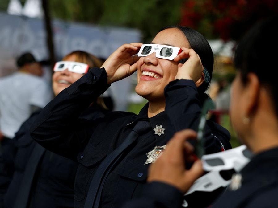 Gli agenti di polizia usano occhiali protettivi per osservare l’eclissi solare, a Torreon, nello stato di Coahuila, in Messico,. REUTERS/Daniel Becerril