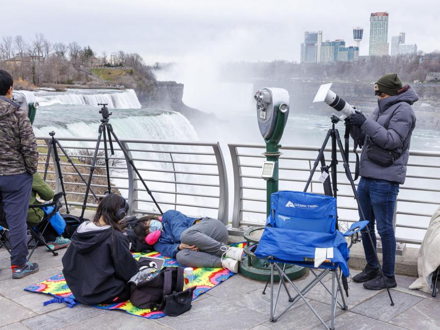 Persone si accampano a Prospect Point poche ore prima dell’eclissi solare totale alle Cascate del Niagara, New York. EPA/SARAH YENESEL