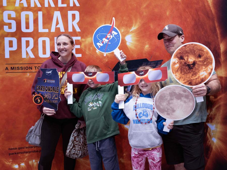 Le persone posano per una foto durante una fiera della scienza presso la Southern Illinois University a Carbondale, Illinois. L’università, come molte comunità in tutto il paese nel percorso dell’eclissi totale dell’8 aprile, sta organizzando eventi legati all’eclissi e si sta preparando a ospitare un massiccio afflusso di visitatori per vedere il raro fenomeno celeste. Scott Olson/Getty Images/AFP