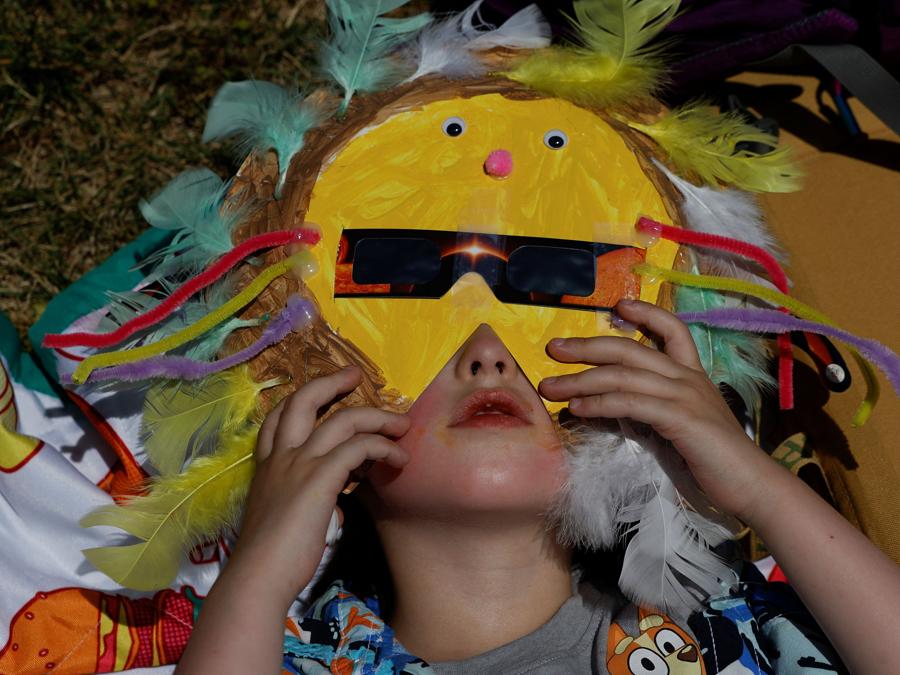 Una bambina indossa una maschera con occhiali per eclissi solare, prima di un’eclissi solare totale, in cui la luna oscurerà il sole, a Carbondale, Illinois, Stati Uniti. REUTERS/Evelyn Hockstein