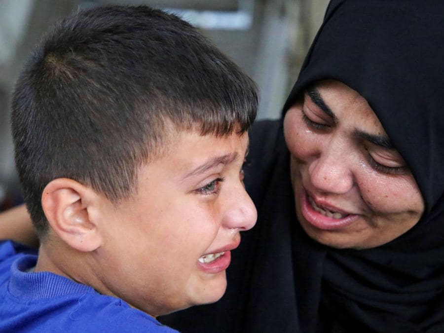 Le persone in lutto piangono durante il funerale dei palestinesi uccisi in un attacco israeliano a Rafah, nel sud della Striscia di Gaza. REUTERS/Hatem Khaled