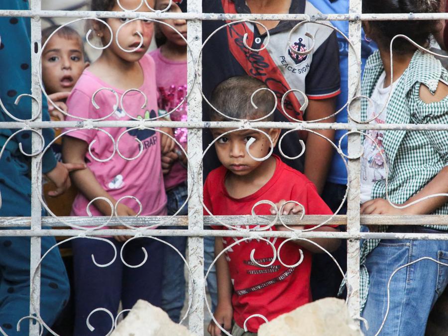 Ragazzini palestinesi  vicino al luogo di un attacco israeliano contro una casa  a Rafah, nel sud della Striscia di Gaza. REUTERS/Hatem Khaled