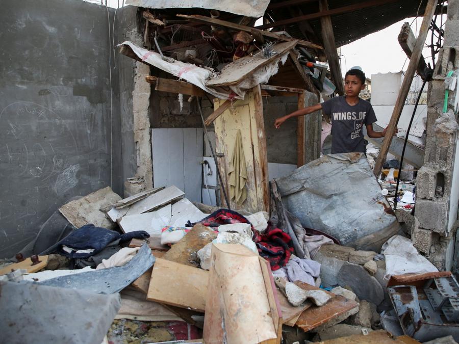 Un ragazzo palestinese ispeziona il luogo di un attacco israeliano contro una casa a Rafah, nel sud della Striscia di Gaza. REUTERS/Hatem Khaled