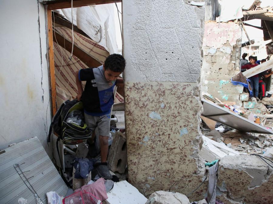 Un ragazzo palestinese ispeziona il luogo di un attacco israeliano contro una casa a Rafah, nel sud della Striscia di Gaza. REUTERS/Hatem Khaled