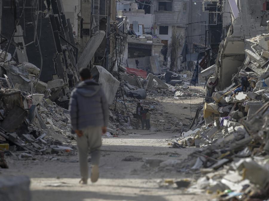 Un uomo palestinese passa davanti agli edifici distrutti a Khan Younis dopo che l’esercito israeliano ha ritirato le truppe dal sud della Striscia di Gaza. EPA/MOHAMMED SABER