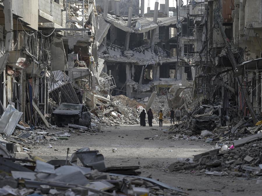 Palestinesi camminano tra edifici distrutti mentre tornano a Khan Younis dopo che l’esercito israeliano ha ritirato le truppe dal sud della Striscia di Gaza. EPA/MOHAMMED SABER