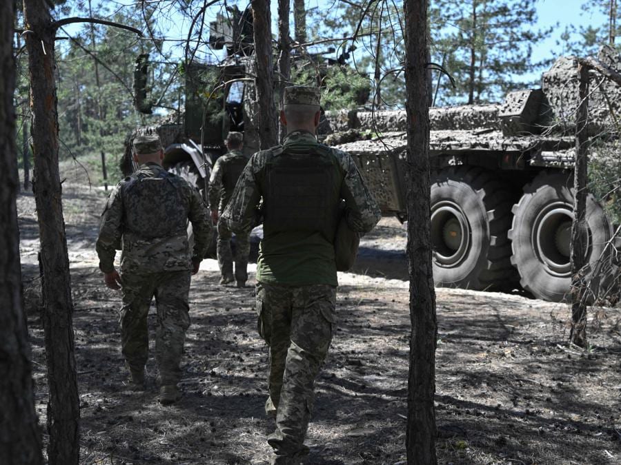 I militari ucraini della 45a brigata di artiglieria aspettano in una foresta per ricevere ordini accanto a un obice semovente di fabbricazione svedese “Archer Artillery System” nella regione di Donetsk. (Photo by Genya SAVILOV / AFP)