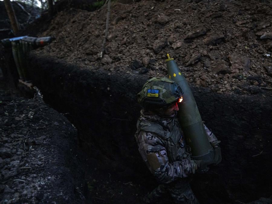 Un militare ucraino della 148a brigata di artiglieria separata delle forze d’assalto aereo delle forze armate ucraine trasporta un proiettile mentre si prepara con i compagni a sparare con un obice trainato leggero M777 verso posizioni russe, sul fronte di Donetsk, Ucraina. (AP Photo/Francisco Seco)