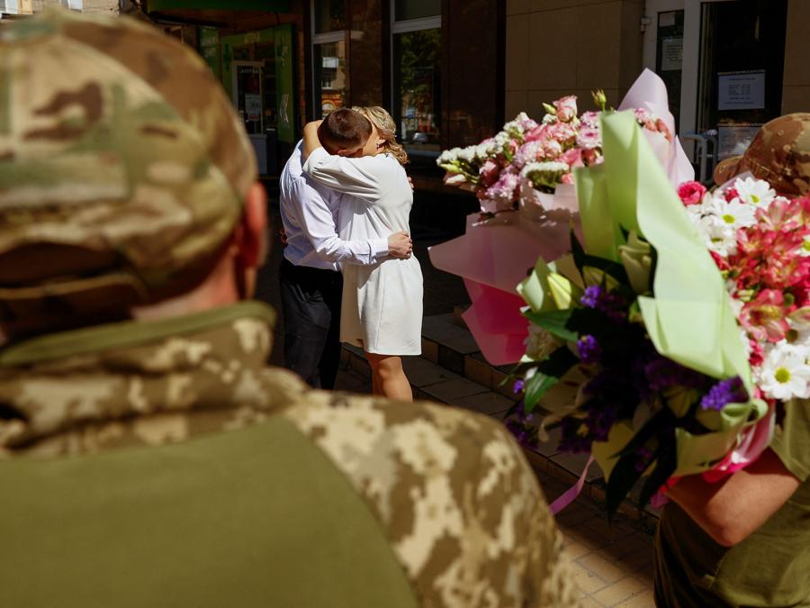Il militare ucraino Yurii bacia sua moglie Viktoriia dopo la cerimonia di matrimonio nella città di Druzhkivka, durante l’attacco della Russia all’Ucraina, vicino alla linea del fronte nella regione di Donetsk, Ucraina. REUTERS/Valentyn Ogirenko
