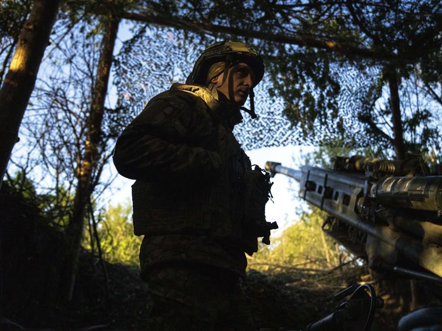 Un militare ucraino della 148a brigata di artiglieria separata delle forze d’assalto aereo delle forze armate ucraine attende l’ordine di sparare con i compagni un obice M777 verso posizioni russe, sul fronte di Donetsk, Ucraina. (AP Photo/Francisco Seco)