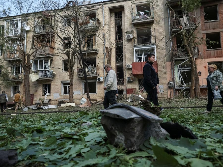 I residenti locali camminano vicino a un condominio danneggiato da un attacco aereo russo, nel mezzo dell’attacco russo all’Ucraina, a Kharkiv, Ucraina. REUTERS/Sofiia Gatilova