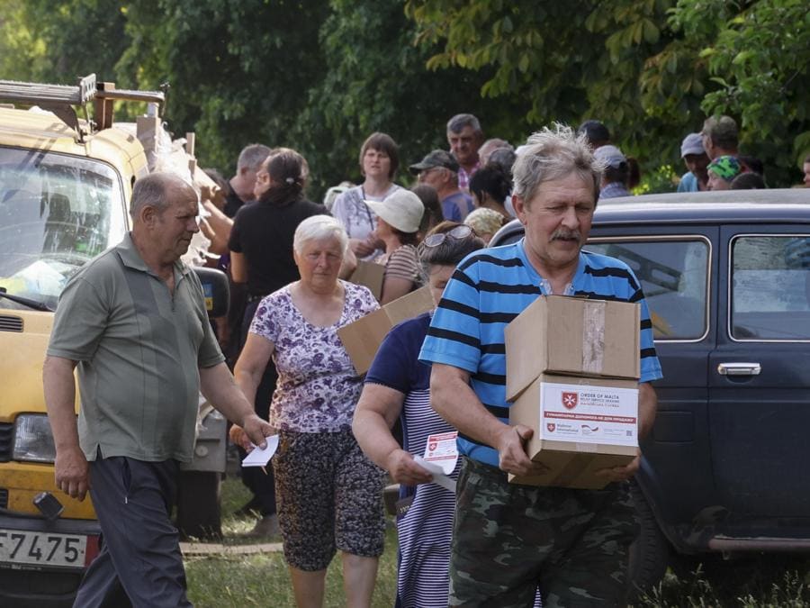 La popolazione locale riceve i set igienici consegnati dai volontari e dal Servizio di Soccorso Ucraina dell’Ordine di Malta come aiuto umanitario nel villaggio di Katerynivka, zona di Kharkiv. EPA/SERGEY KOZLOV
