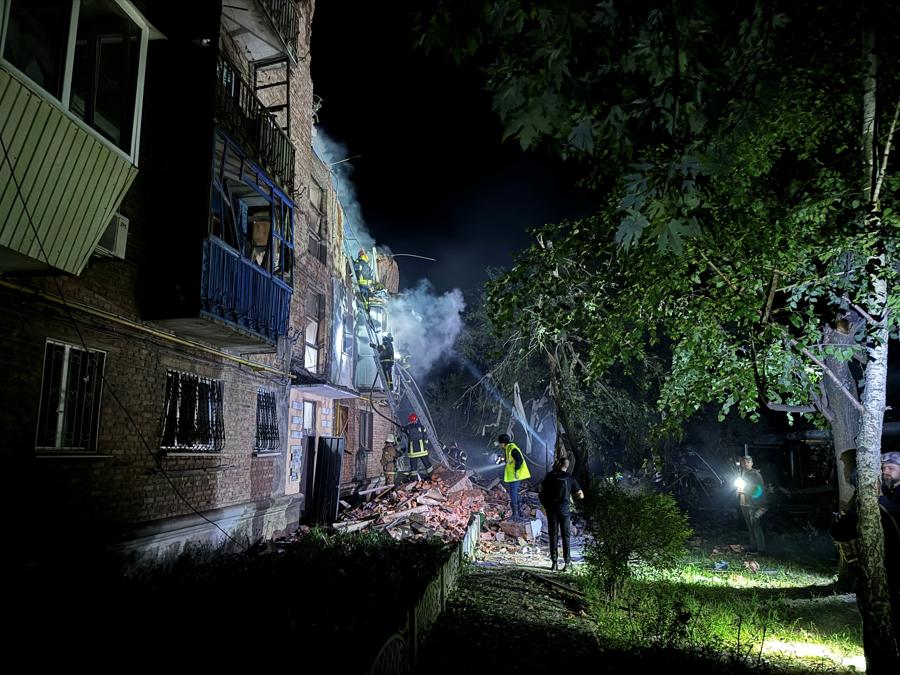 I vigili del fuoco lavorano sul sito di un edificio residenziale colpito da un attacco missilistico russo a Kharkiv. REUTERS/Vitalii Hnidyi