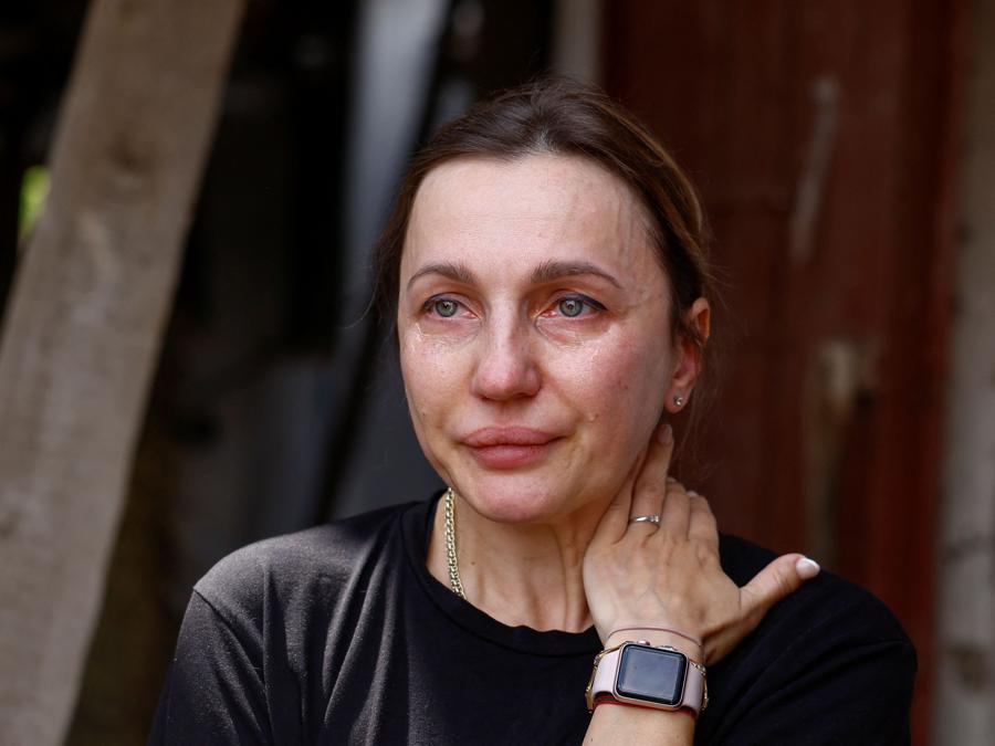 Tetiana Ihnatieva, docente e volontaria dell’Università statale di biotecnologia, che conduce terapia assistita con cavalli per i membri del servizio ucraini feriti, piange nel sito della scuola di equitazione sportiva per bambini e giovani gravemente danneggiata dagli attacchi missilistici russi, nel mezzo dell’attacco della Russia all’Ucraina, nel villaggio di Mala Danylivka, fuori Kharkiv. REUTERS/Valentyn Ogirenko