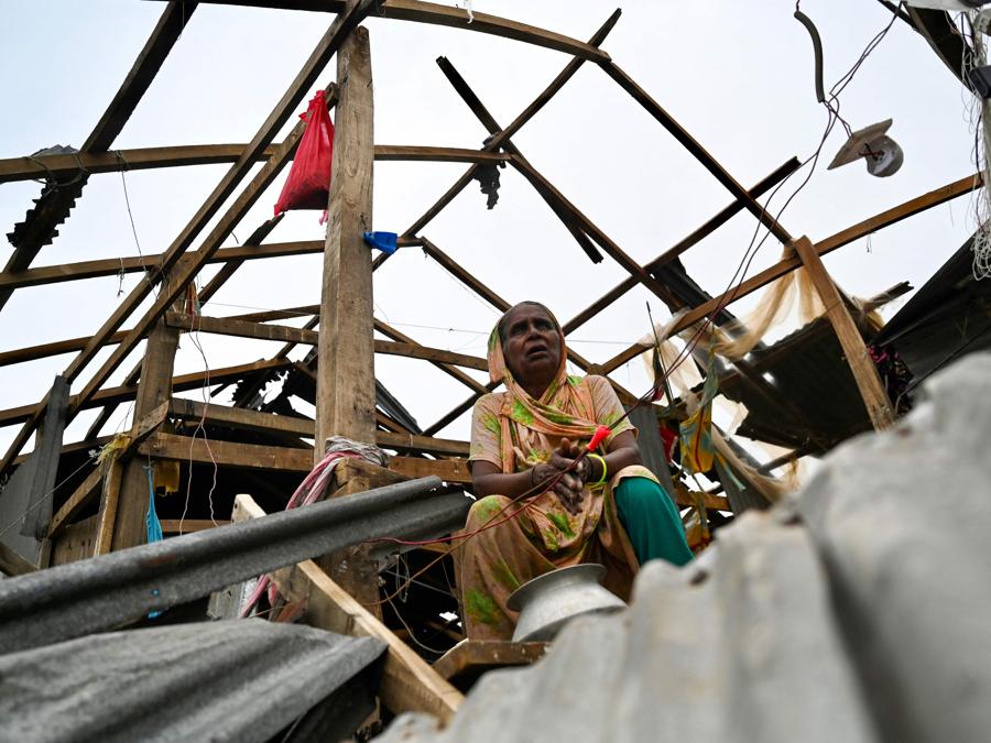 Una donna siede nella sua casa danneggiata dopo l’atterraggio del ciclone Remal a Patuakhali . Il ciclone Remal, che si è abbattuto sulle pianure del Bangladesh e sulla vicina India la sera del 26 maggio con violente tempeste e onde che si infrangono, ha provocato la morte di almeno 21 persone , hanno distrutto migliaia di case, distrutto dighe marittime e allagato città nei due paesi. (Photo by Munir Uz Zaman / AFP)