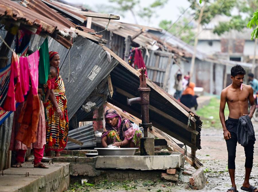 Una donna lava gli utensili nella sua casa danneggiata dopo l’atterraggio del ciclone Remal a Patuakhali il 28 maggio 2024. Il ciclone Remal, che si è abbattuto sulle zone basse del Bangladesh e sulla vicina India la sera del 26 maggio con violente tempeste e onde che si infrangono, ha lasciato almeno 21 persone morti, distrussero migliaia di case, distrussero dighe marittime e inondarono città nei due paesi. (Photo by Munir Uz Zaman / AFP)