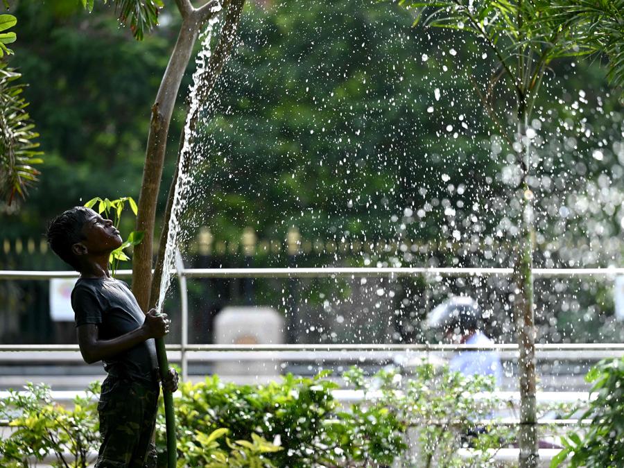 Un ragazzo gioca con l’acqua durante una calda giornata estiva a Chennai. (Photo by R.Satish BABU / AFP)