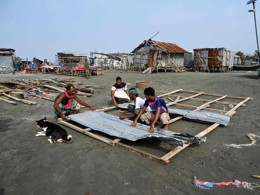 Uomini riparano il loro negozio danneggiato dopo l’atterraggio del ciclone Remal a Patuakhali. Il ciclone Remal, che si è abbattuto sulle pianure del Bangladesh e sulla vicina India la sera del 26 maggio con violente tempeste e onde che si infrangono, ha provocato la morte di almeno 38 persone, distrutto migliaia di case, distrutto dighe marine e allagato città nei due paesi. (Photo by Munir Uz Zaman / AFP)