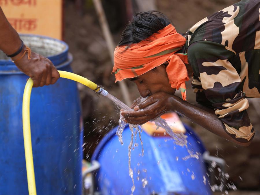 Un operaio beve acqua in una calda giornata estiva a Lucknow. (AP Photo/Rajesh Kumar Singh)